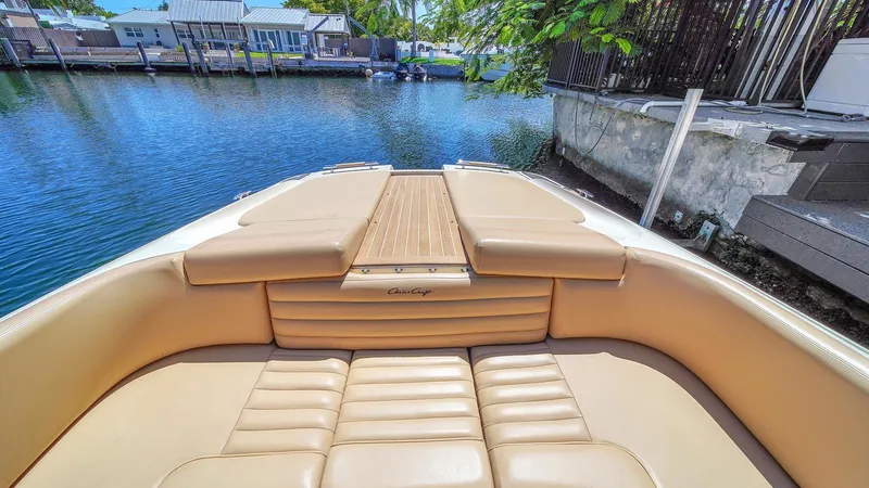 Levi Yacht Photos Pics 2013 Chris-Craft Launch 32 boat with tan leather seating, docked by a serene waterfront.