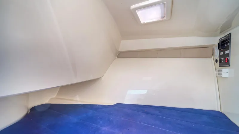 Levi Yacht Photos Pics 2013 Chris-Craft Launch 32 cabin interior with blue upholstery and overhead light.