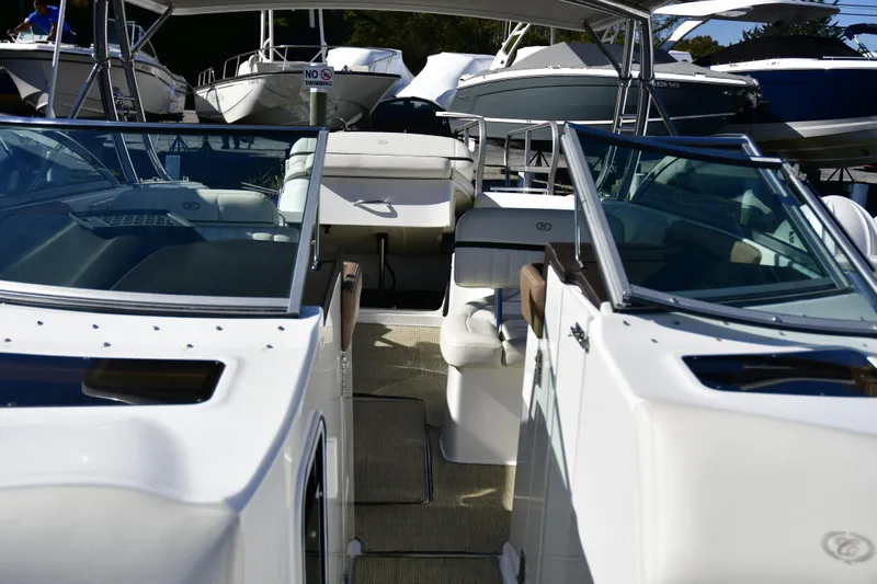 Yacht Photos Pics 2016 Cobalt 336 boat interior with seating and glass windshields, docked among other boats.