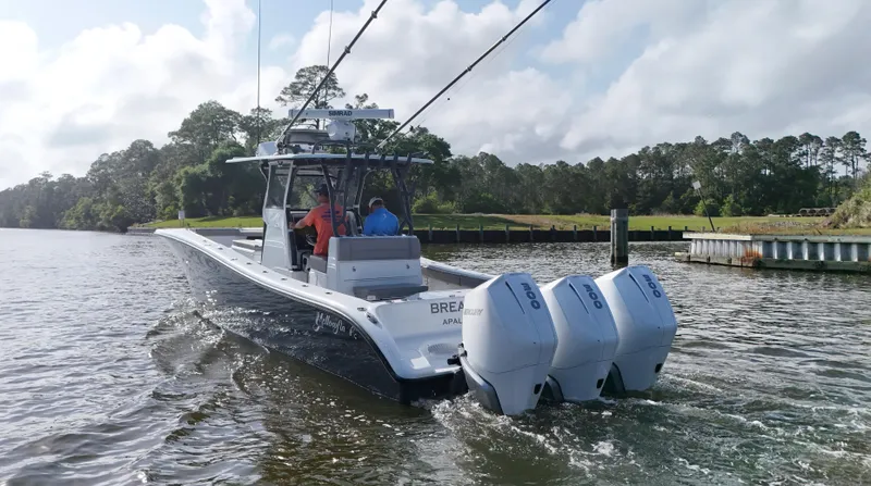 Engine Warranty X Trailer Yacht Photos Pics 2022 Yellowfin 34 boat cruising on a river with triple outboard engines.