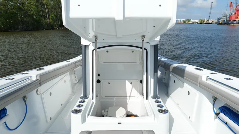 Engine Warranty X Trailer Yacht Photos Pics 2022 Yellowfin 34 boat interior with open storage compartment on calm water.