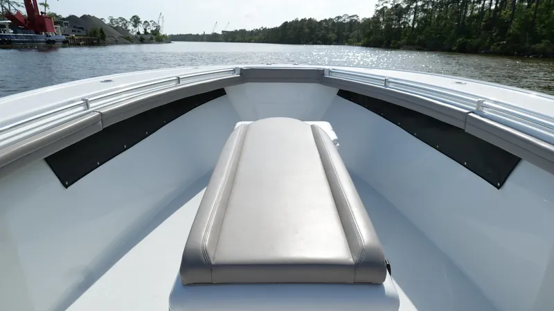Engine Warranty X Trailer Yacht Photos Pics 2022 Yellowfin 34 boat interior with cushioned seating on a calm waterway.