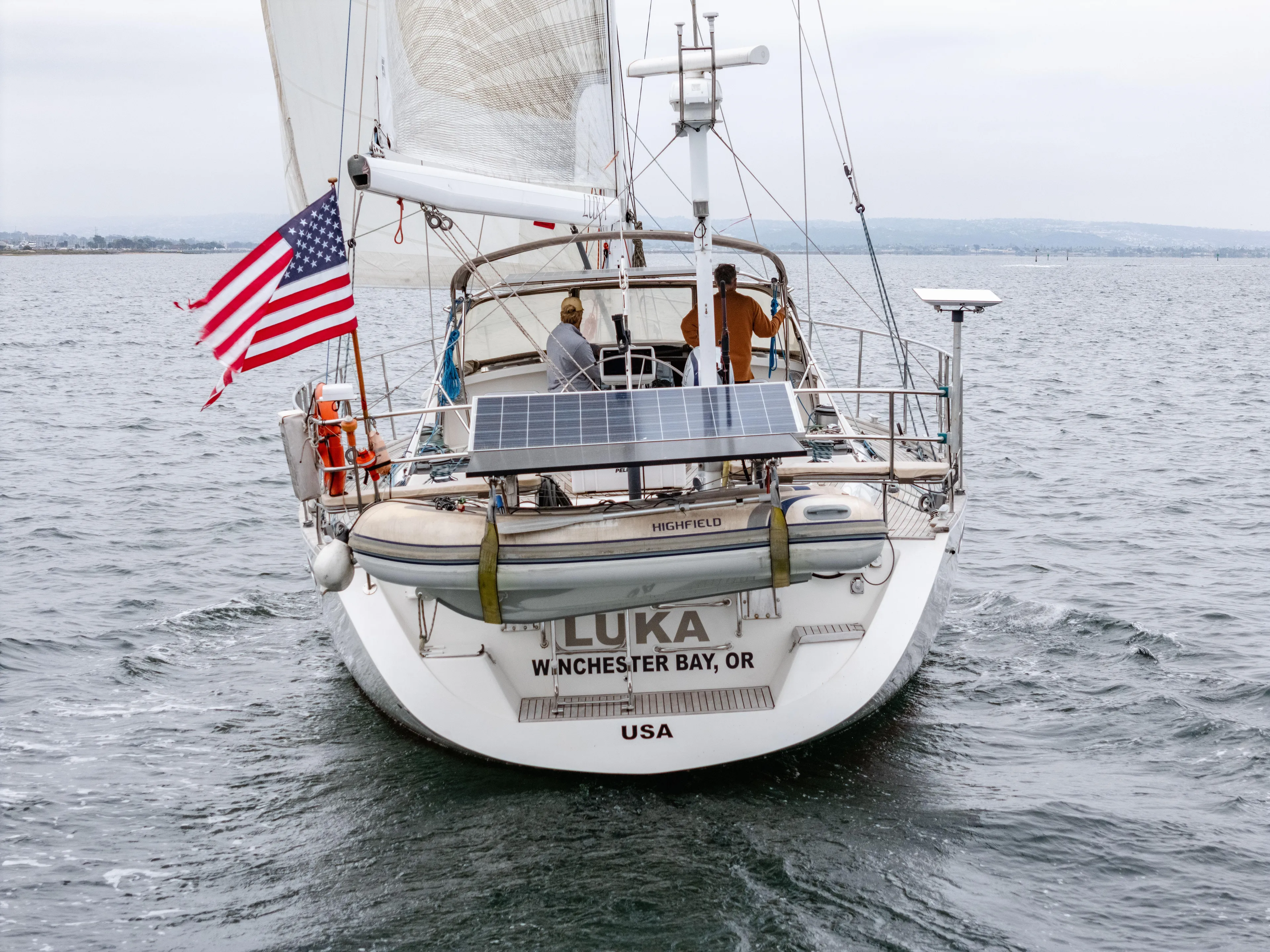 Luka Yacht Photos Pics Sailing yacht Farr 60 Pilot House 1997 with solar panels and American flag on open water.