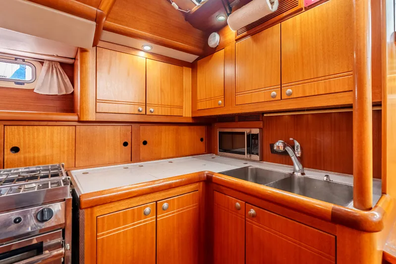 Luka Yacht Photos Pics 1997 Farr 60 Pilot House yacht kitchen with wooden cabinets and modern appliances.
