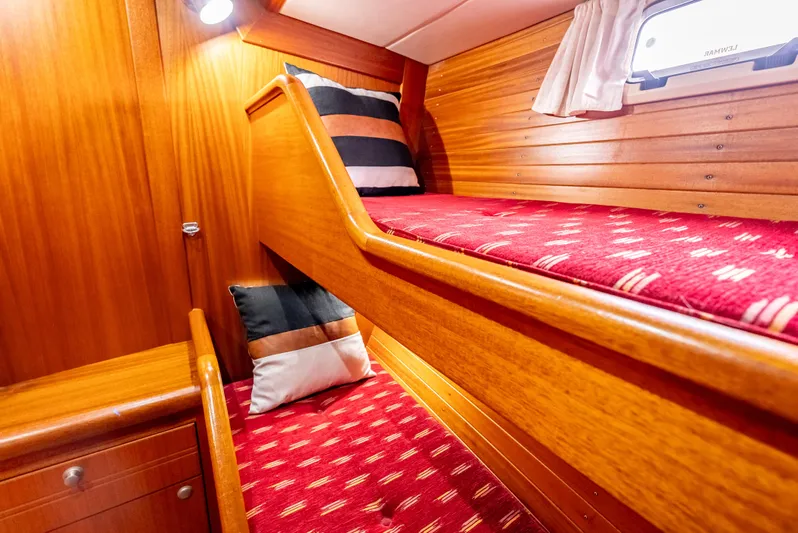 Luka Yacht Photos Pics Bunk beds in 1997 Farr 60 Pilot House with red patterned bedding and wooden interior.