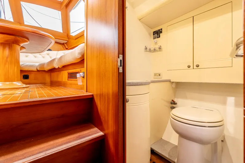 Luka Yacht Photos Pics Interior of 1997 Farr 60 Pilot House yacht, featuring wooden stairs and compact bathroom.