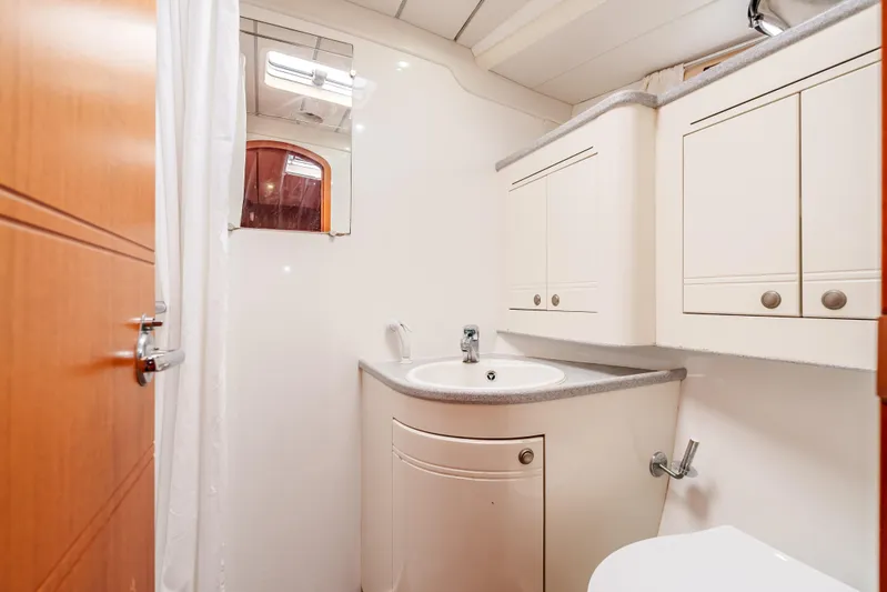 Luka Yacht Photos Pics Bathroom interior of 1997 Farr 60 Pilot House yacht, featuring white cabinetry and sink.