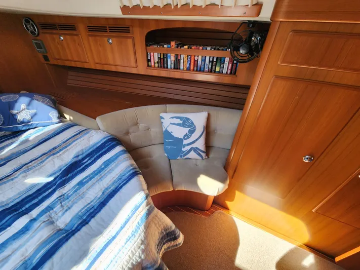 Bonnefooi Yacht Photos Pics Cozy cabin interior of 2008 Hallberg-Rassy 62 yacht with bed, books, and seating area.