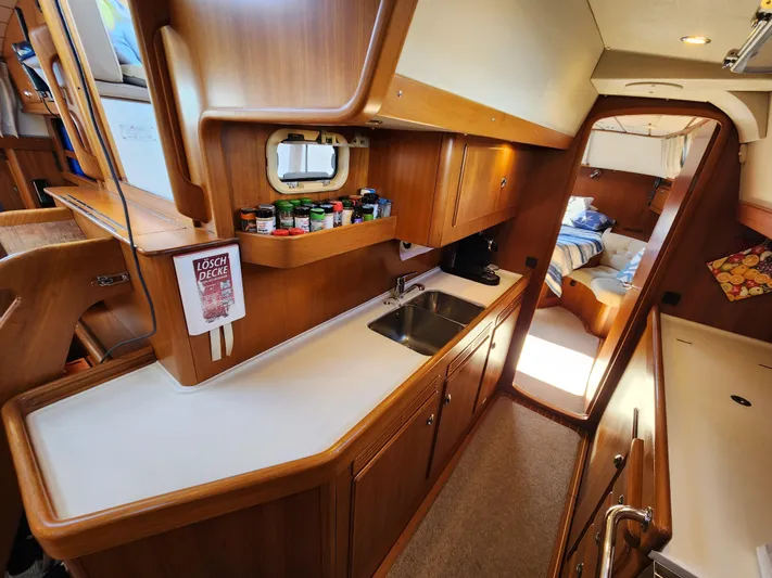 Bonnefooi Yacht Photos Pics Interior of 2008 Hallberg-Rassy 62 yacht, featuring a wooden kitchen and cozy cabin.