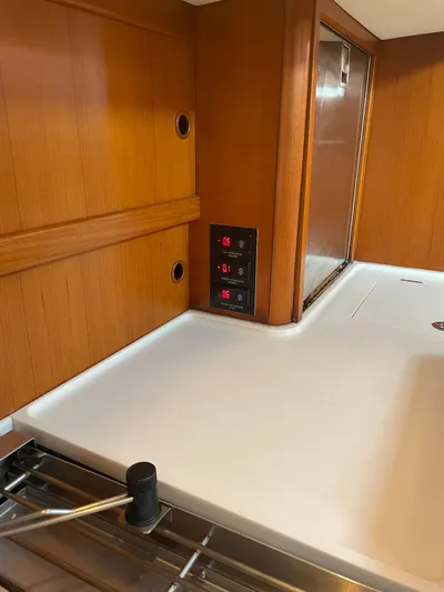 Bonnefooi Yacht Photos Pics Interior of 2008 Hallberg-Rassy 62 yacht with wooden paneling and control switches.