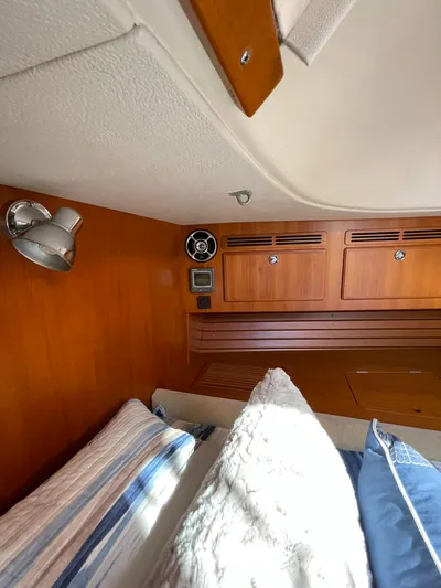 Bonnefooi Yacht Photos Pics Interior cabin of 2008 Hallberg-Rassy 62 yacht with wooden paneling and cozy bedding.