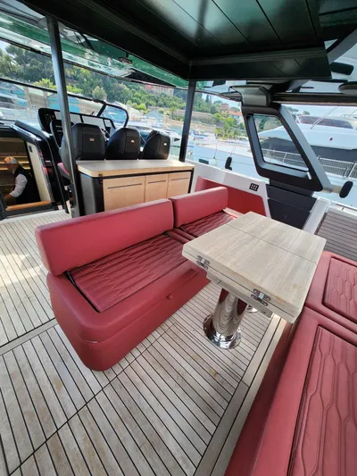  Yacht Photos Pics 2022 Cranchi A46 Luxury Tender interior with red seating and wooden table.