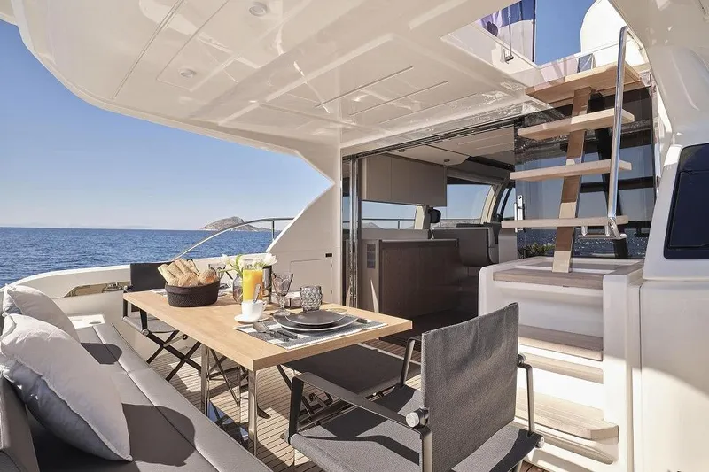  Yacht Photos Pics Luxurious 2022 Ferretti Yachts 550 with elegant outdoor dining area and ocean view.
