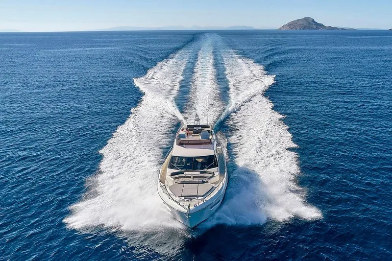  Yacht Photos Pics 2022 Ferretti Yachts 550 cruising on open sea with island in background.
