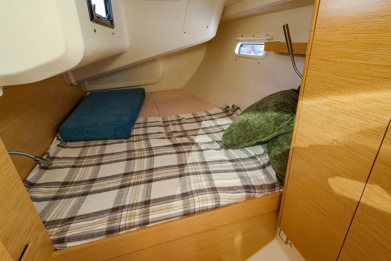  Yacht Photos Pics Cozy cabin interior of 2022 Hanse 388 yacht with plaid bedding and cushions.