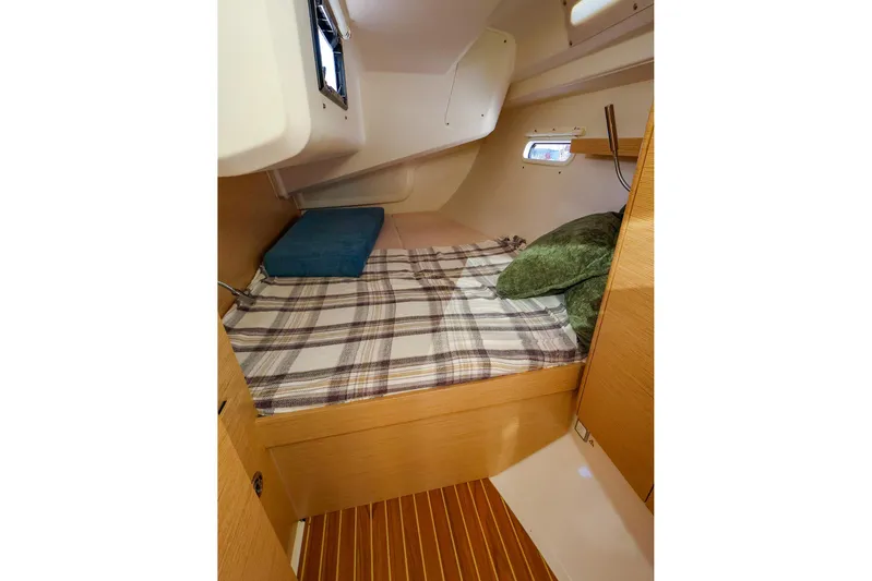  Yacht Photos Pics Cozy cabin interior of 2022 Hanse 388 yacht with plaid bedding and pillows.