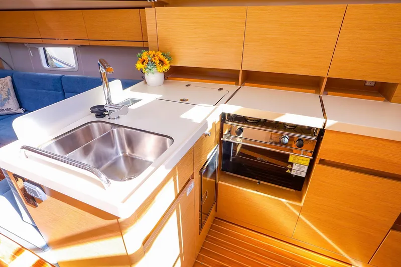  Yacht Photos Pics Modern kitchen interior of 2022 Hanse 388 yacht with sink, stove, and wooden cabinetry.