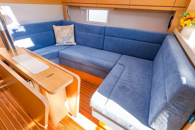  Yacht Photos Pics Luxurious 2022 Hanse 388 yacht interior with blue seating and wooden accents.