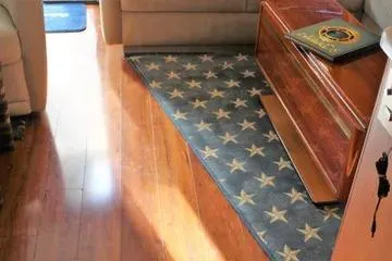 Island Dancer Yacht Photos Pics Interior of 1996 Ocean 53 Super Sport yacht with star-patterned rug and wooden flooring.