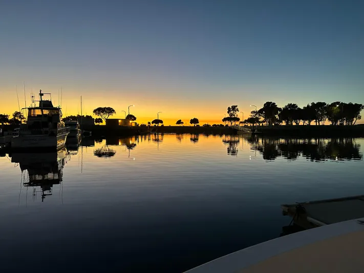 Hydrotherapy Yacht Photos Pics Sunset over marina with Jefferson 52 Rivanna Aft Cabin, 1999, reflecting on calm water.
