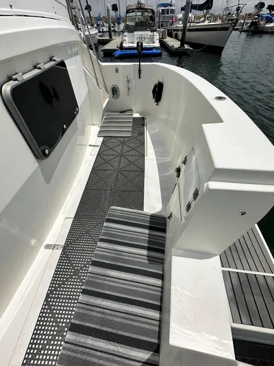 Hydrotherapy Yacht Photos Pics 1999 Jefferson 52 Rivanna Aft Cabin yacht deck with striped mats, docked at marina.