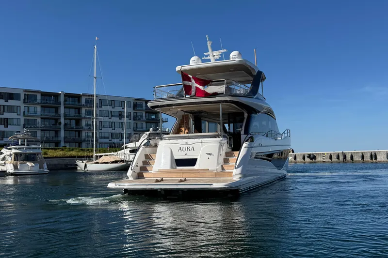  Yacht Photos Pics Luxury 2022 Princess Y72 yacht "Aura" docked in a marina under clear blue skies.