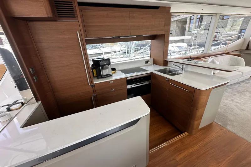  Yacht Photos Pics Luxurious 2022 Princess Y72 yacht kitchen with modern wood cabinetry and sleek countertops.