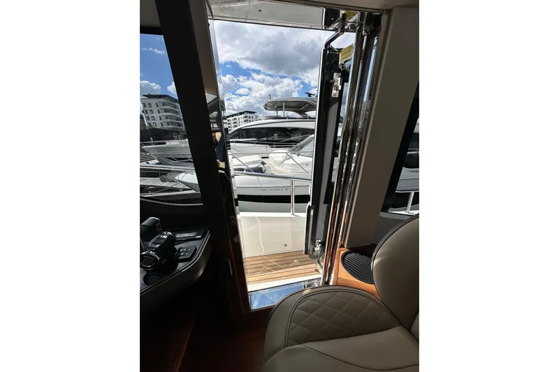  Yacht Photos Pics Interior view of 2022 Princess Y72 yacht, showcasing luxurious seating and marina backdrop.