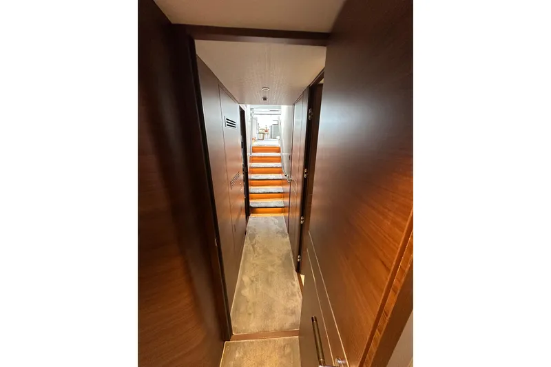  Yacht Photos Pics Narrow hallway with wooden walls and stairs on a 2022 Princess Y72 yacht.