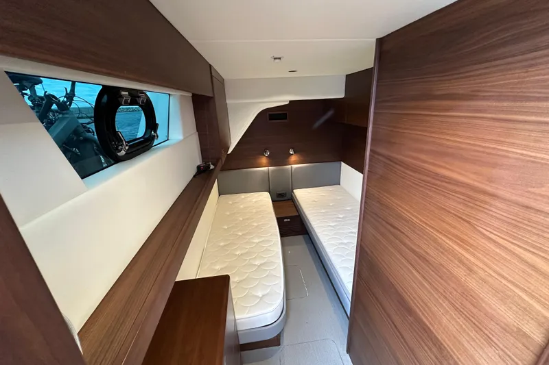  Yacht Photos Pics Interior of 2022 Princess Y72 yacht cabin with twin beds and wooden paneling.