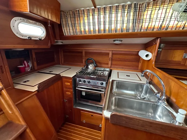 Elusive Yacht Photos Pics 1987 Hinckley Sou'wester 42 yacht kitchen with stove, sink, and wooden cabinetry.