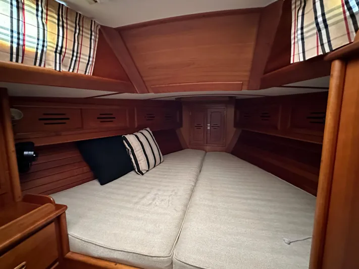 Elusive Yacht Photos Pics Cozy cabin interior of 1987 Hinckley Sou'wester 42 sailboat with wood finish and striped curtains.