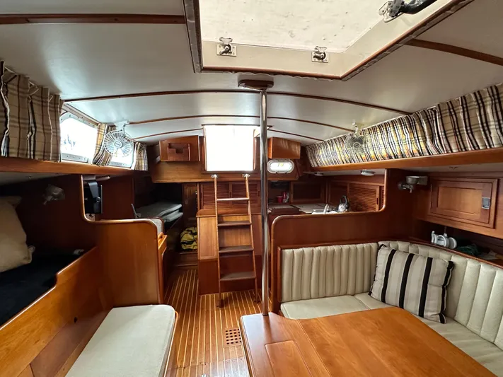 Elusive Yacht Photos Pics Interior of 1987 Hinckley Sou'wester 42 sailboat with wood finish and seating area.