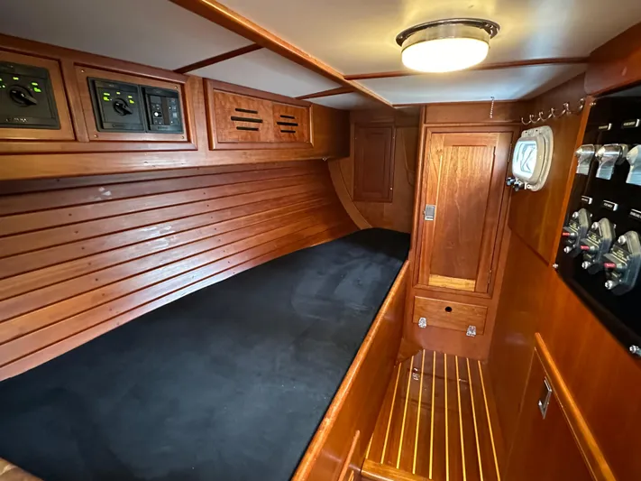 Elusive Yacht Photos Pics 1987 Hinckley Sou'wester 42 cabin interior with wooden paneling and black cushioned berth.
