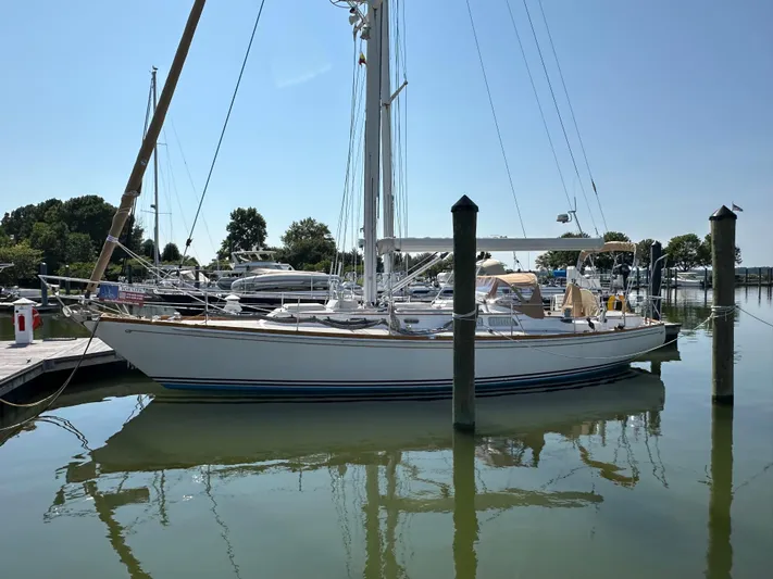 Elusive Yacht Photos Pics 1987 Hinckley Sou'wester 42 sailboat docked in a marina, reflecting on calm water.