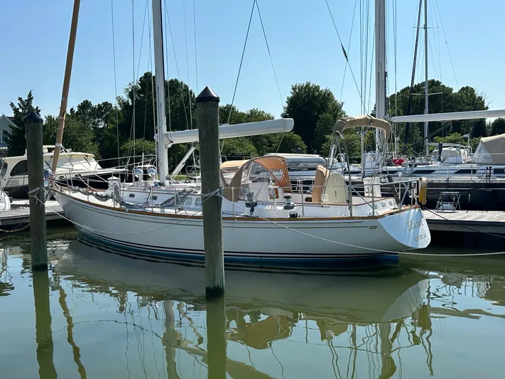 Elusive Yacht Photos Pics 1987 Hinckley Sou'wester 42 sailboat docked in a marina, reflecting on calm water.