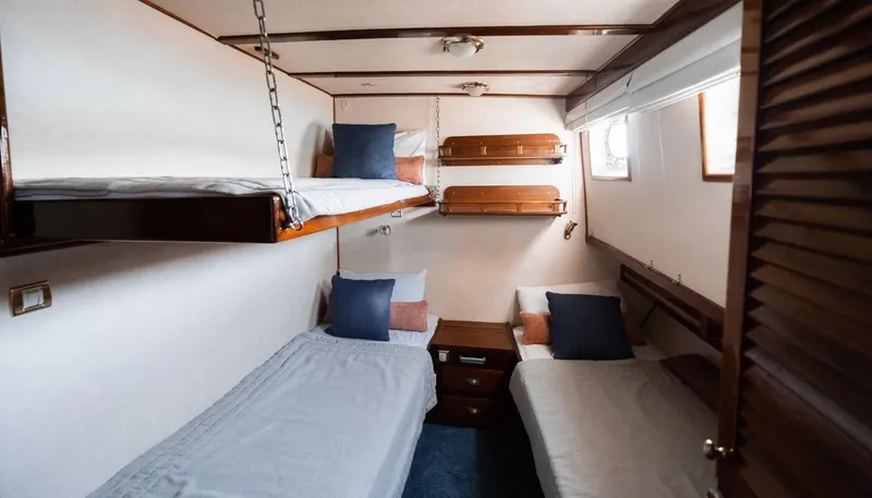 Kaiki Yacht Photos Pics Cozy cabin interior of 1974 Greek traditional sailing yacht with bunk beds and wooden decor.