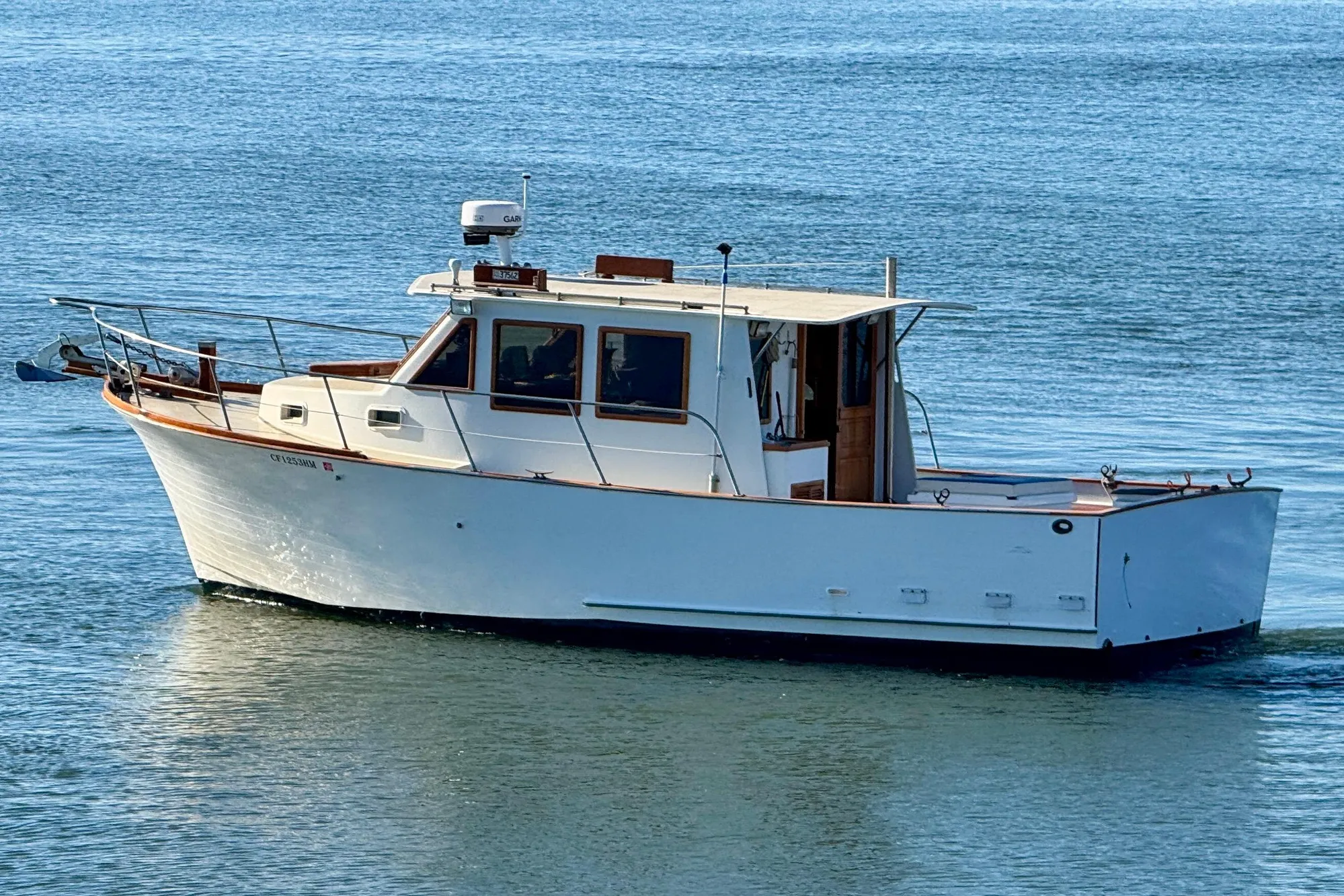 1982 Tung Hwa Seahorse boat on calm blue water, side view.