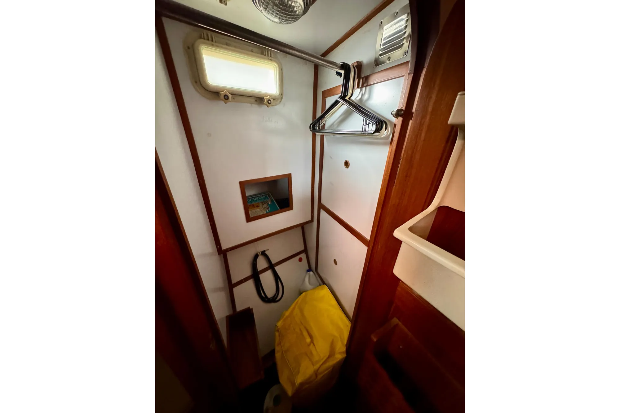 1982 Tung Hwa Seahorse interior closet with hangers, window, and storage space.