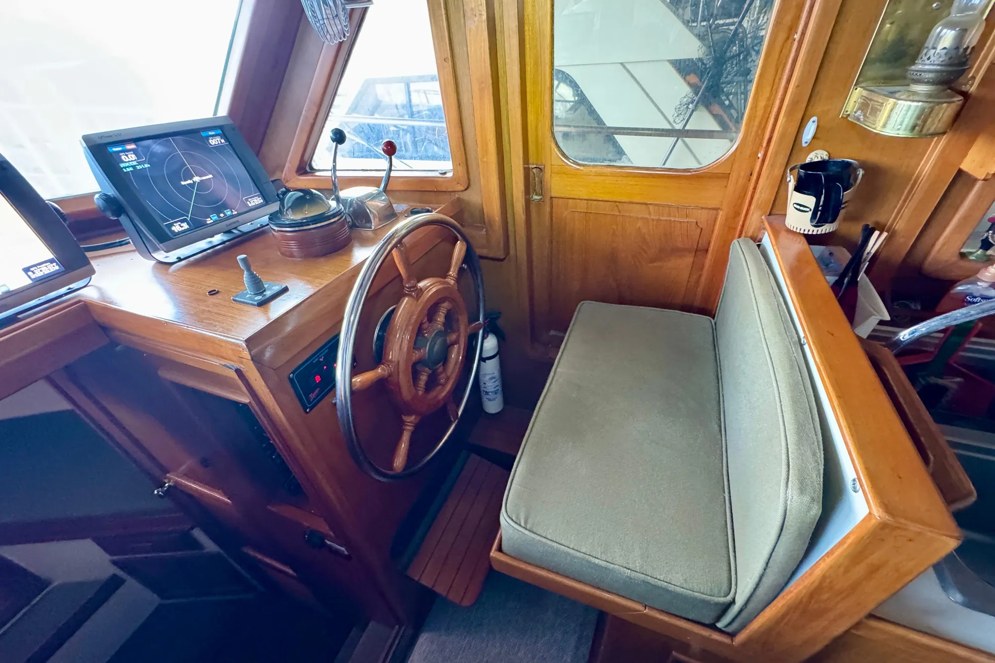 1982 Tung Hwa Seahorse helm with wooden wheel, navigation screens, and cushioned seat.