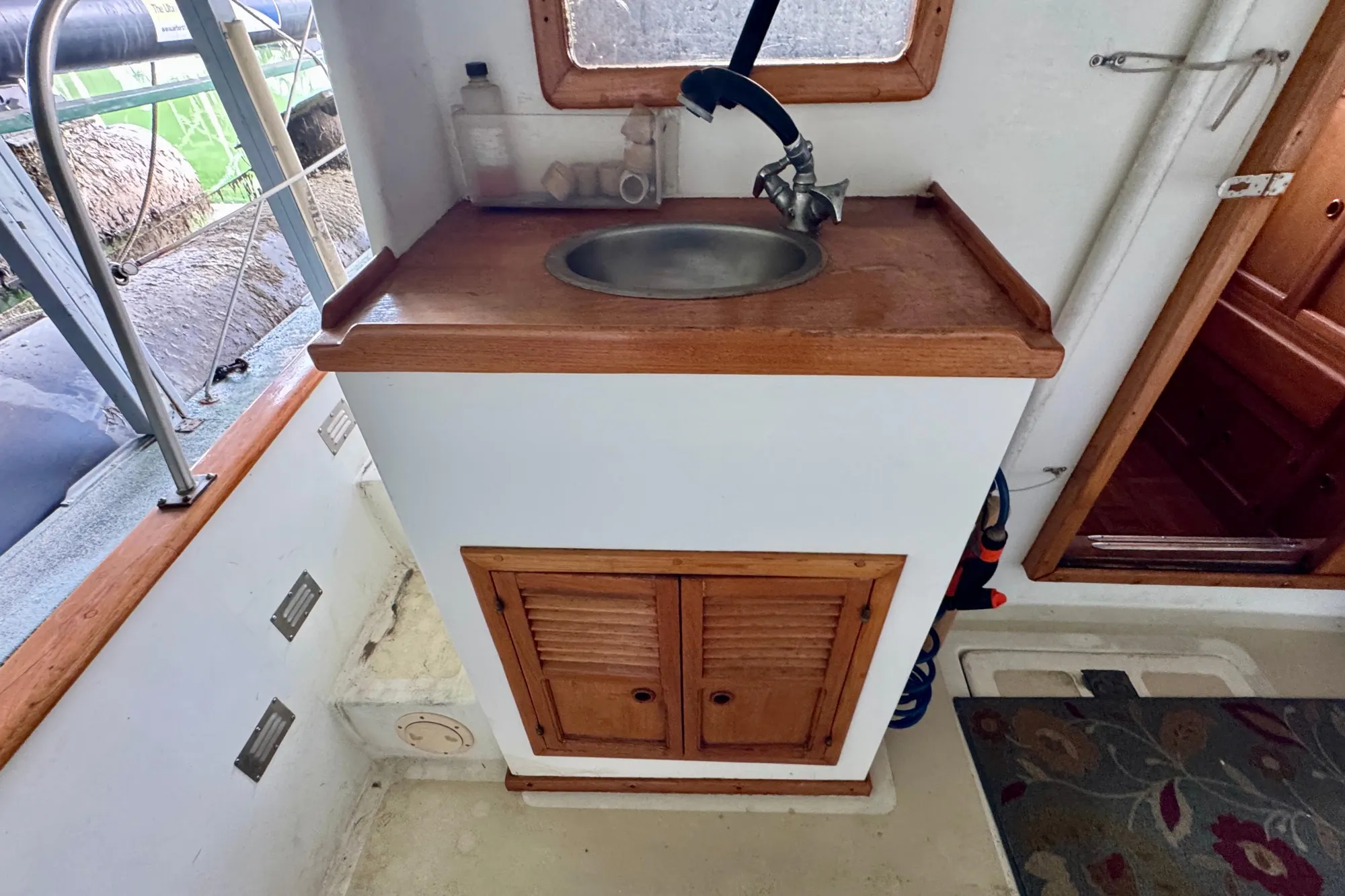 1982 Tung Hwa Seahorse boat interior with wooden sink cabinet and faucet.