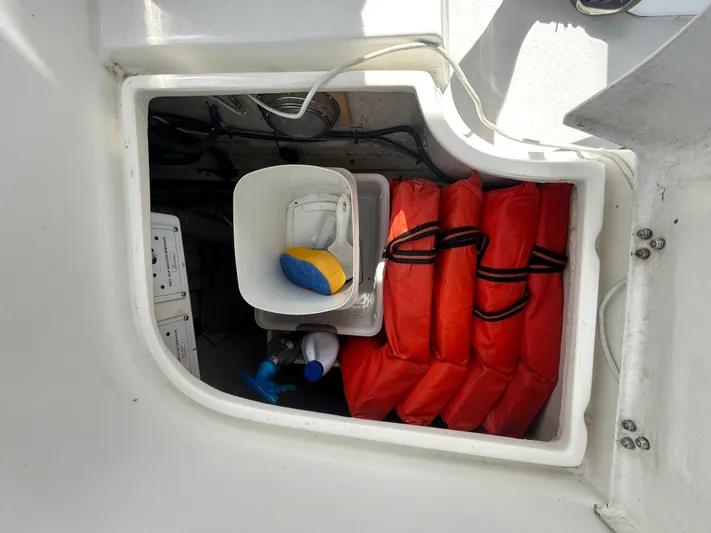 Dream Weaver Yacht Photos Pics Storage compartment on a 2003 Catalina 350 sailboat with life jackets and cleaning supplies.
