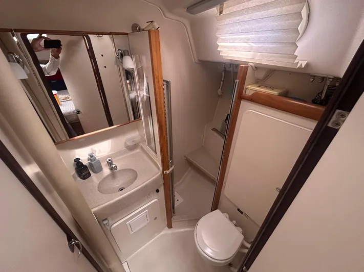 Dream Weaver Yacht Photos Pics Compact bathroom in a 2003 Catalina 350 yacht, featuring sink, mirror, and toilet.