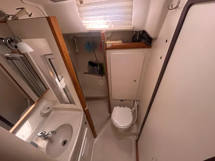 Dream Weaver Yacht Photos Pics Compact bathroom in a 2003 Catalina 350 sailboat with sink, toilet, and shower.