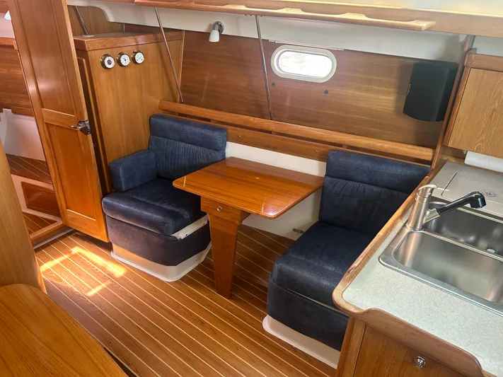 Dream Weaver Yacht Photos Pics Interior of 2003 Catalina 350 sailboat with wooden furnishings and blue seating.