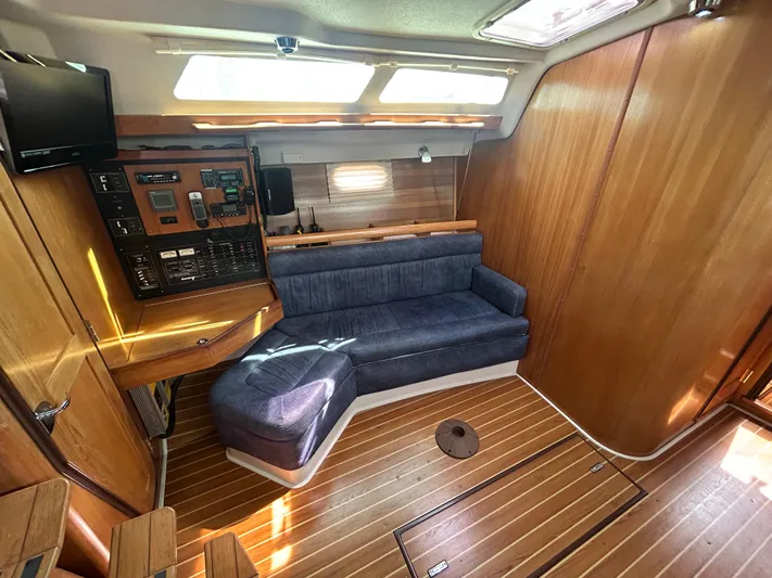 Dream Weaver Yacht Photos Pics Interior of 2003 Catalina 350 sailboat with blue sofa and wooden paneling.