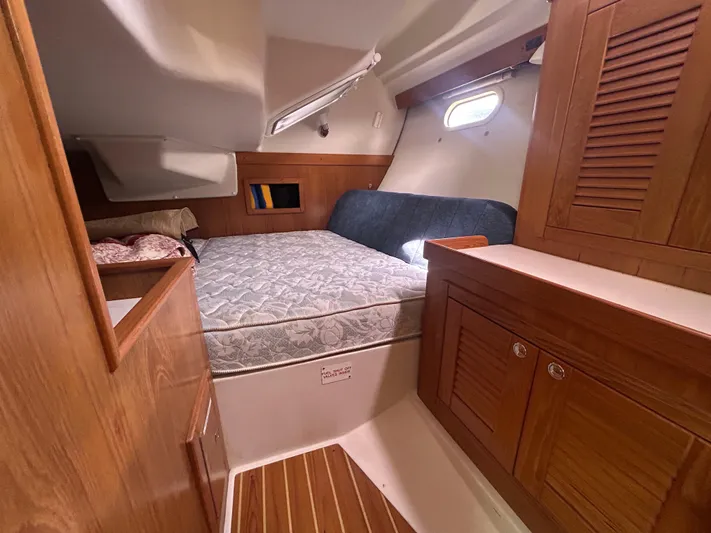 Dream Weaver Yacht Photos Pics Cozy cabin interior of 2003 Catalina 350 sailboat with wooden cabinetry and bed.