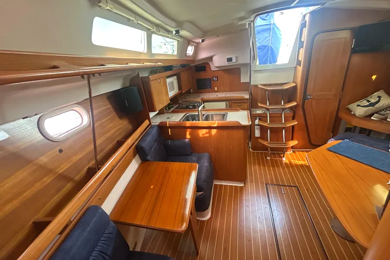 Dream Weaver Yacht Photos Pics Interior of 2003 Catalina 350 sailboat with wood finish, dining area, and compact kitchen.
