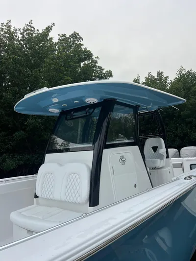  Yacht Photos Pics 2023 Sportsman Open 302 Center Console boat with blue T-top and white seating.