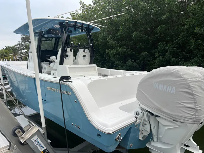  Yacht Photos Pics 2023 Sportsman Open 302 Center Console boat with Yamaha engine, docked near greenery.
